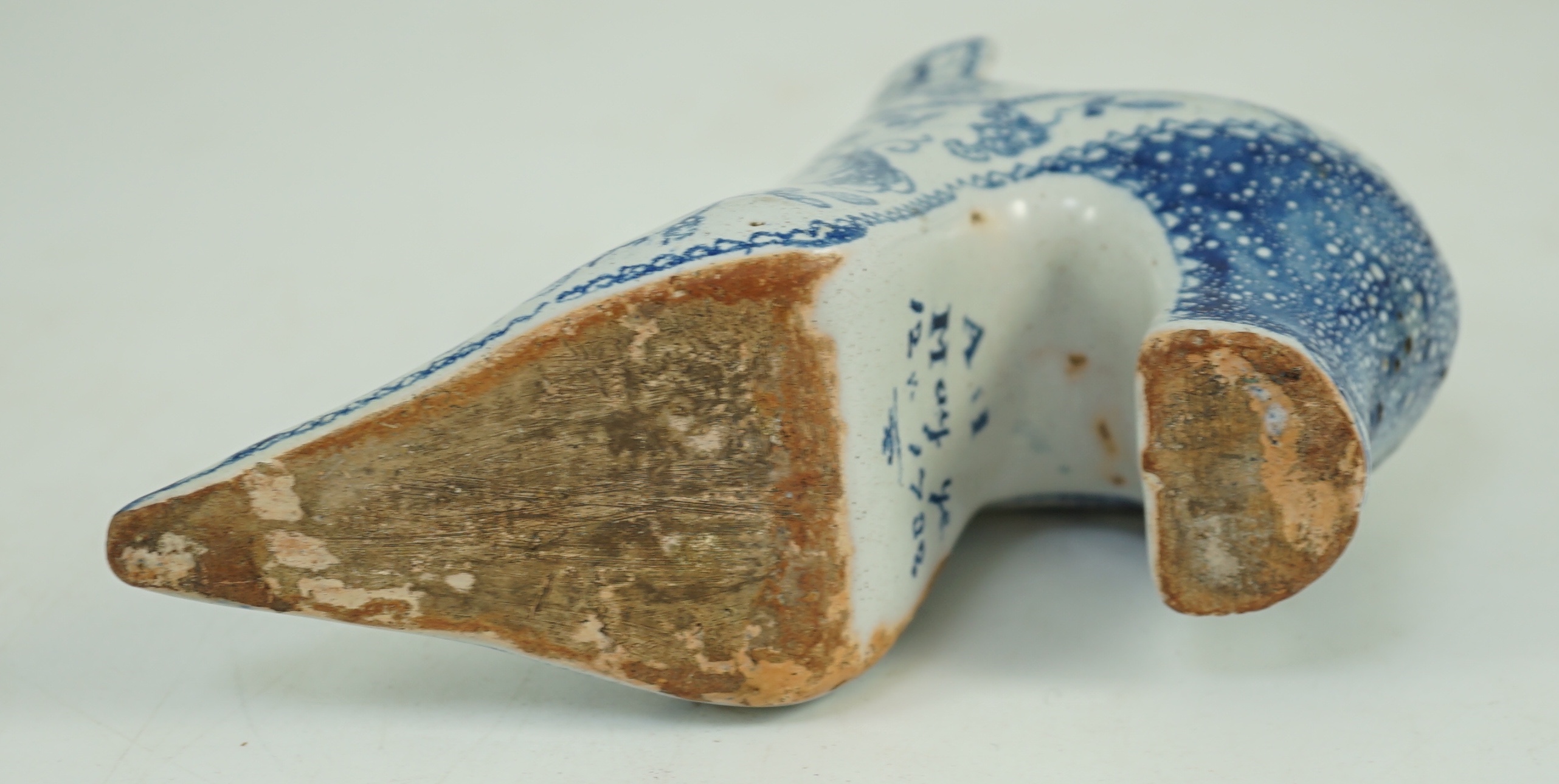 A documentary English delftware blue and white model of a shoe, dated 1732, 16cm long, damage